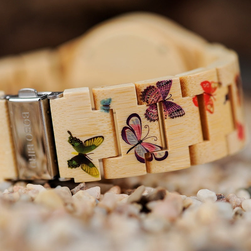 Wooden bracelet with butterfly designs on a pebble surface