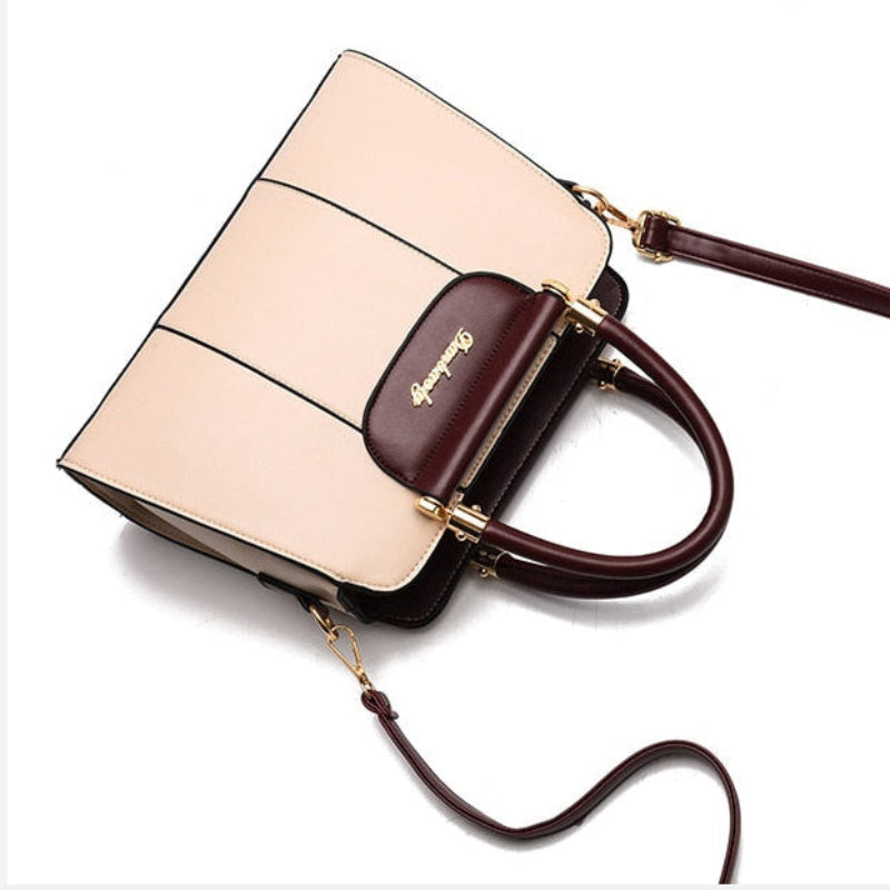 Beige handbag with brown accents on a white background, featuring the brand name 'Kate Spade'.