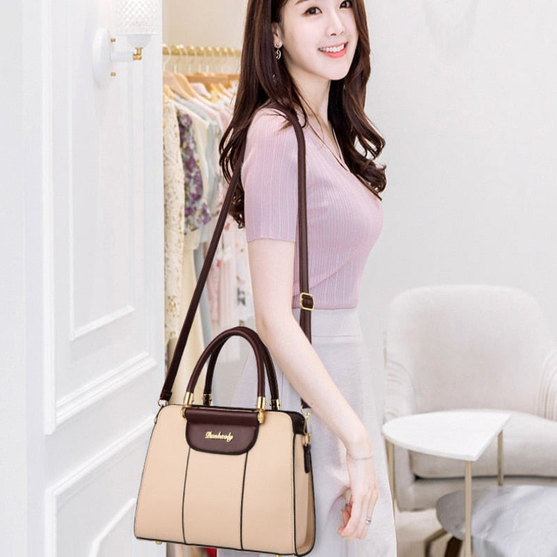 Woman holding a beige handbag in an indoor setting