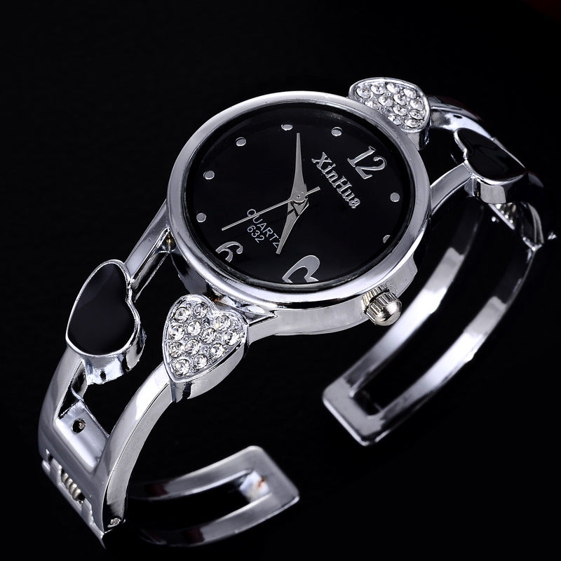 Silver bracelet watch with black dial on a black background