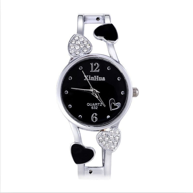 Wristwatch with black dial and heart-shaped design on a white background