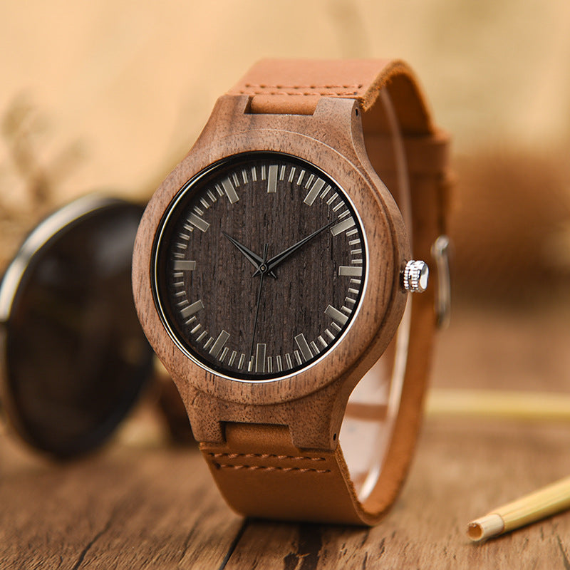 Wooden watch with brown leather strap on a wooden surface