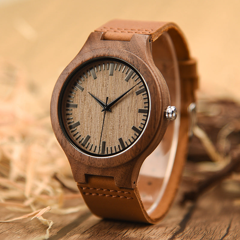 Wooden watch with brown leather strap on a wooden surface