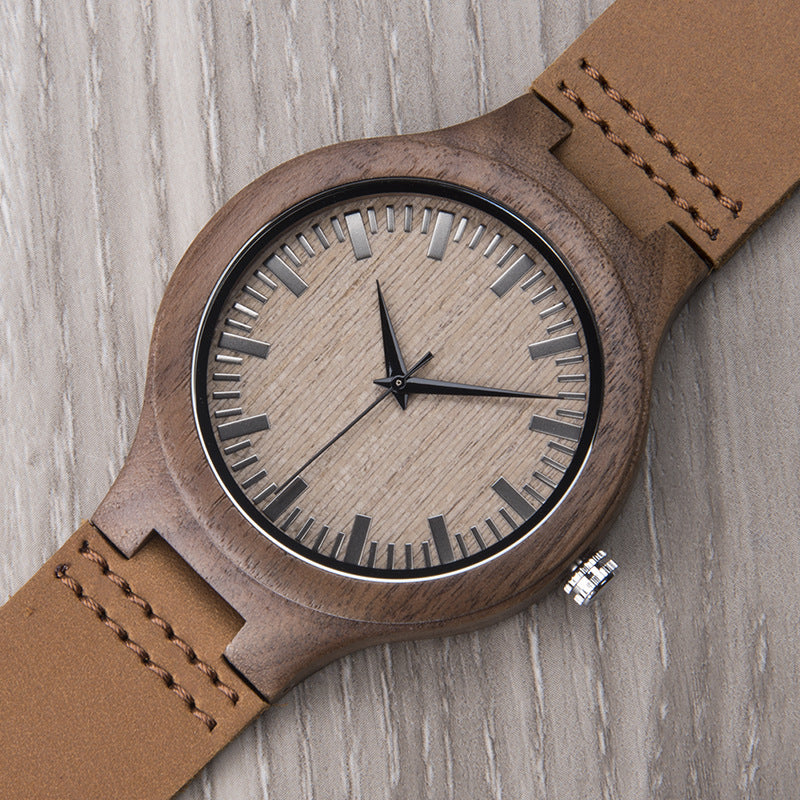 Wooden watch with brown leather strap on a wooden surface