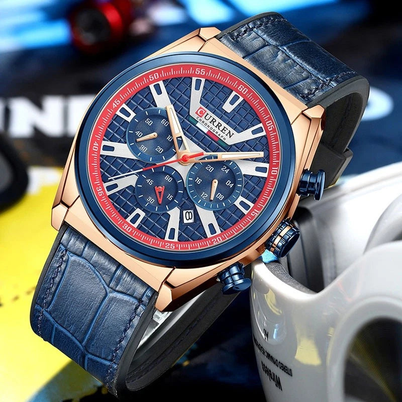 A luxury men's chronograph watch by CURREN, featuring a textured blue dial with white and red accents, a rose gold-tone case, and a dark blue alligator leather strap.