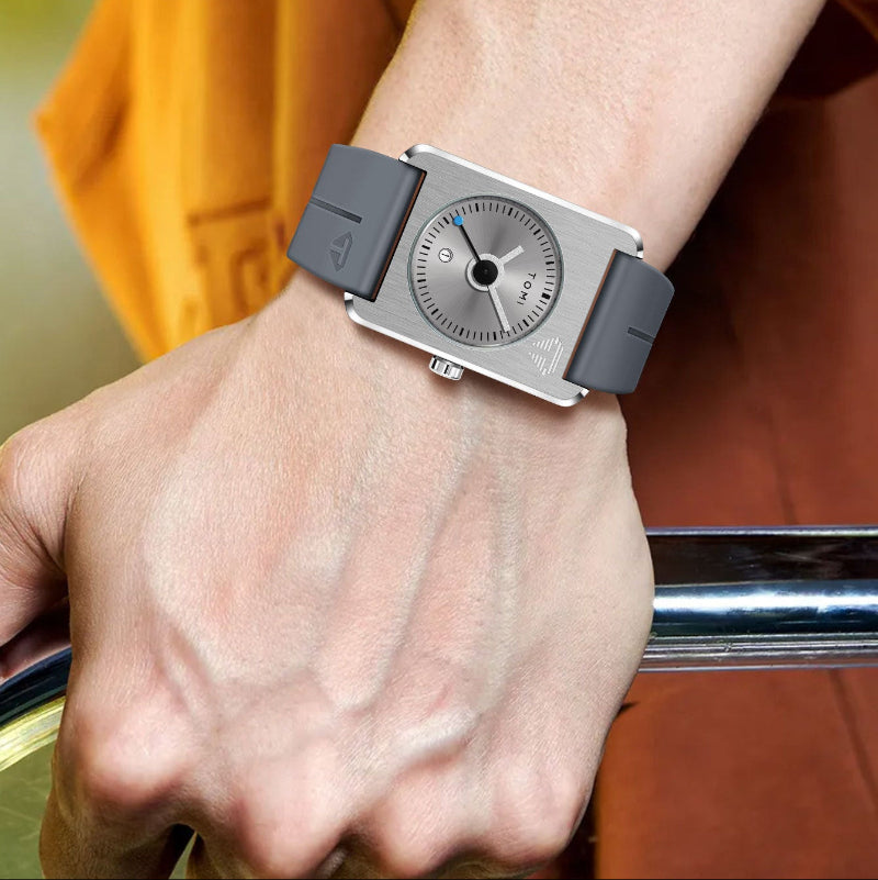 Person wearing a unique watch with a gray strap and silver case.