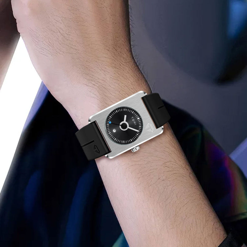 Wrist wearing a black and silver watch with a blurred background
