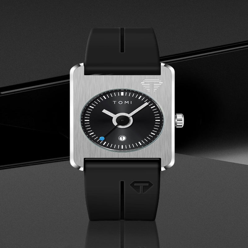 A Tomi analog watch with a brushed silver rectangular case, black dial, and black silicone strap, shown against a dark gray background.