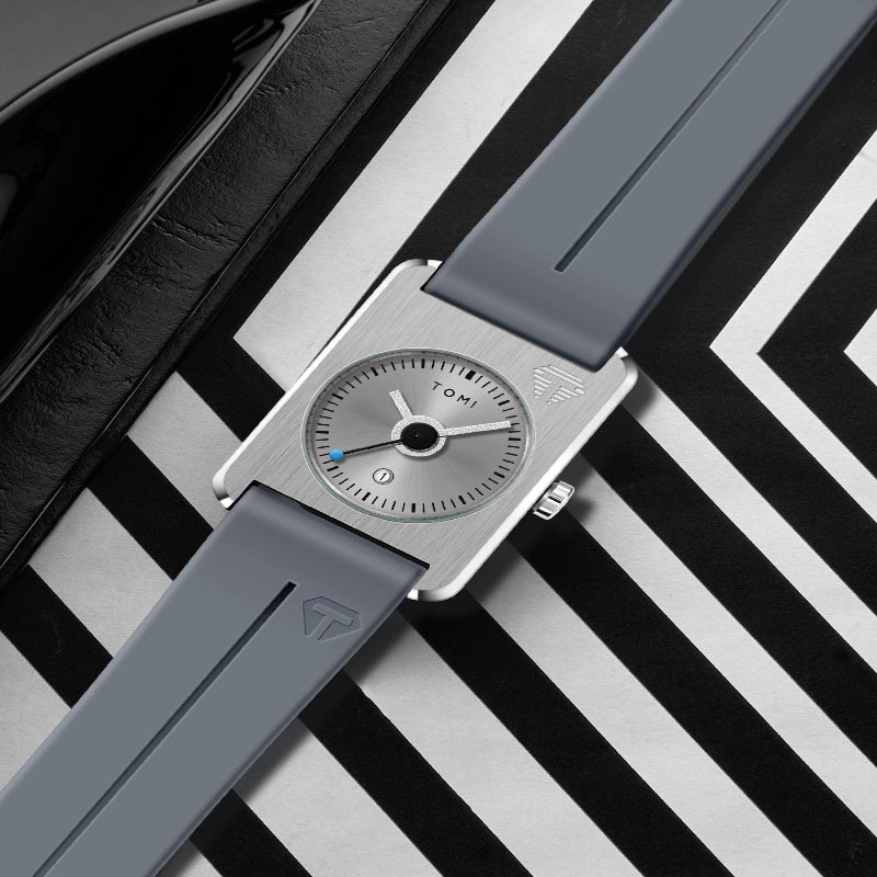 Watch with gray strap and silver case on a black and white striped background