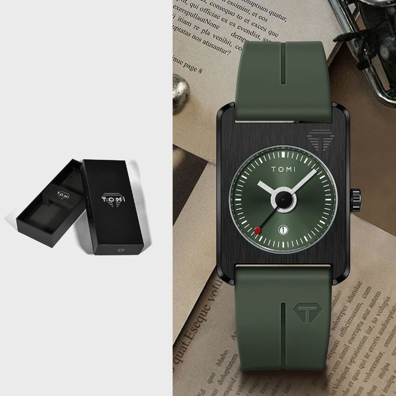 Green watch with black case on a textured surface, next to a black box with 'TOMI' branding.