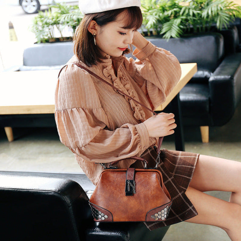 Woman holding a brown handbag in an indoor setting