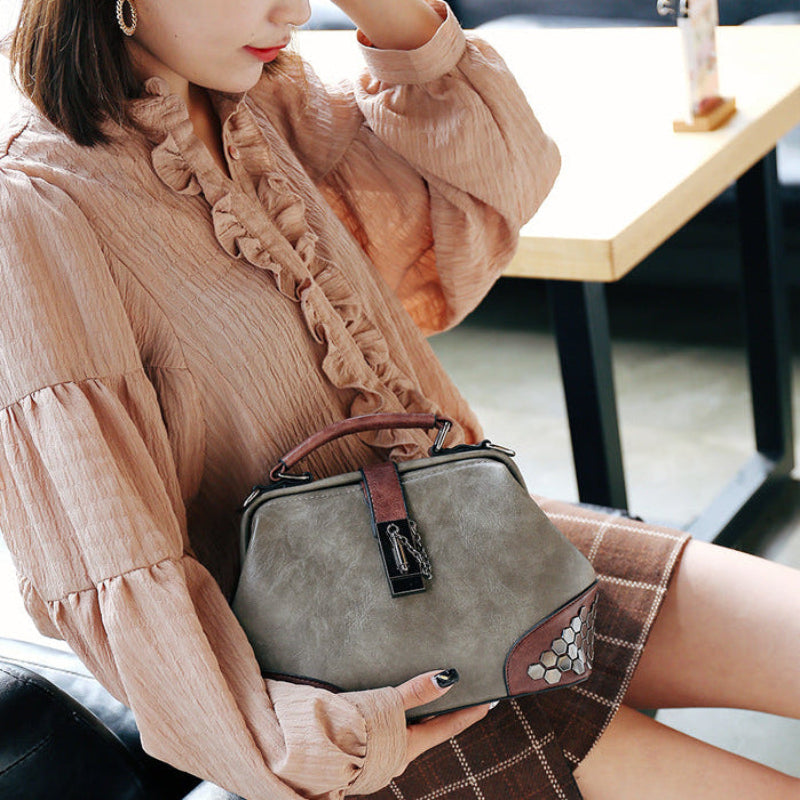 Woman holding a gray handbag