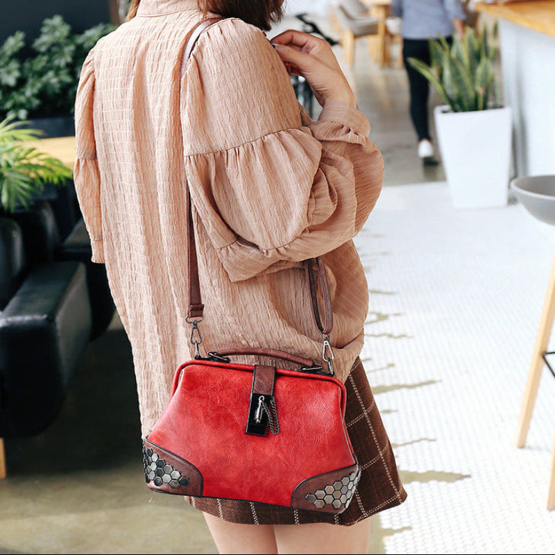 Woman holding a red handbag in an outdoor setting