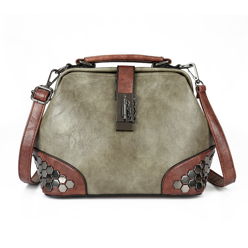 Vintage-style handbag with brown accents and metal embellishments on a white background